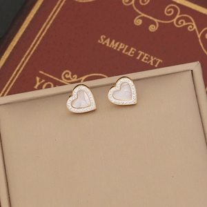 Golden heart earrings with mother of pearl and crystal pavé on a vintage display