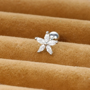 Macro shot of a flower zircon stud earring with screw back on brown velvet padding