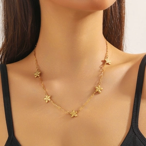 Fashionable gold-plated stainless steel necklace featuring textured star charms on model