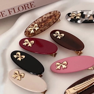 Ins-style oval hair clips with metal bows in assorted colors displayed on a white base