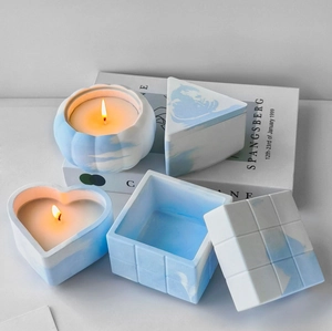 Close-up of geometric storage containers and candles with blue marble texture pattern