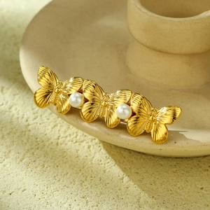 Makroaufnahme einer eleganten goldenen Schmetterlings-Haarklammer mit Perlenverzierung