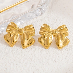 Macro shot of 18k gold plated stainless steel bow earrings with a polished mirror finish