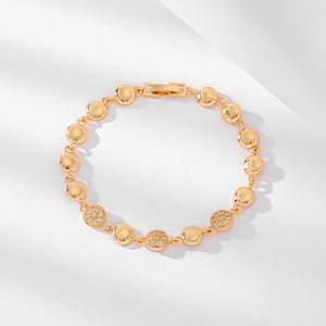 Nahaufnahme eines vergoldeten Armbands mit Zirkonia-Besatz und geprägten Mustern