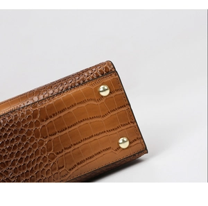 Detail of brown crocodile pattern leather with golden metal protective base studs