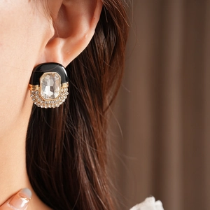 Detail view of vintage black enamel stud earrings with rectangular crystal and rhinestones