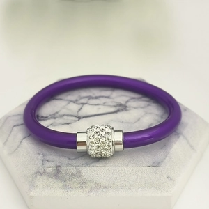 Details des lila Silikonarmbands mit silberner Perle und funkelnden weißen Kristallen