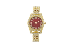 Close-up of golden iced-out watch featuring red dial with Roman numerals and rhinestones