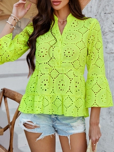 Détail de la blouse vert fluo à col en V avec broderie anglaise délicate et ourlet volanté