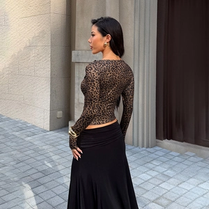 Detail of the ruffle edge and slim fit leopard print long sleeve top with black maxi skirt