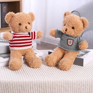 Adorable teddy bear plush toys wearing striped and grey sweaters on white carpet