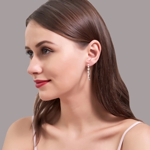 Macro detail of large silver hoop earrings featuring micro-pave cubic zirconia on a model