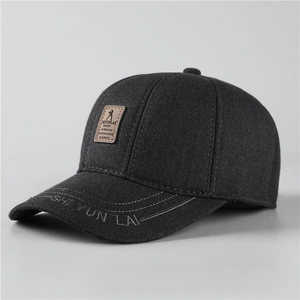 Detail of grey winter baseball cap showing textured fabric and leather logo patch