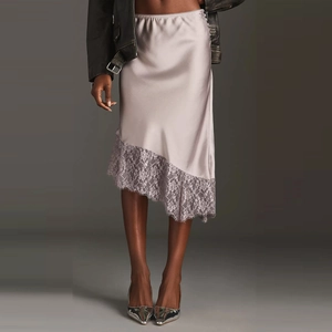 Detail of light purple satin skirt with delicate lace trim and asymmetrical hemline