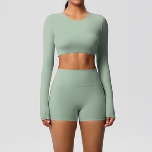 Detail of sage green yoga set with high-waist shorts and long sleeve crop top