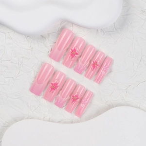 Pink gradient French press-on nails with 3D floral accents and gold beads in coffin shape