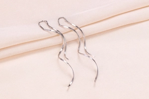 Macro shot of silver S925 long wavy double-track geometric threader earrings