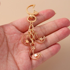 Chic gold alloy moon and star keychain pendant held by hand for backpack accessory
