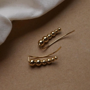 Detail of gradient golden bead crawler earrings in S925 sterling silver on fabric