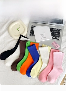 Detailed macro view of colorful ribbed cotton socks in nine shades on a white bed