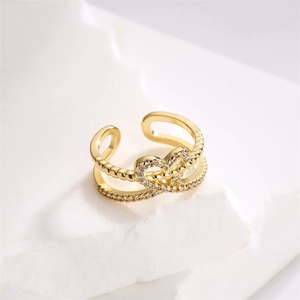 Close-up of gold plated double layer heart ring with sparkling zircon stones on stone