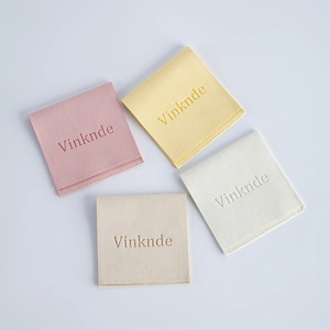 Flat lay of colorful velvet jewelry pouches in pink and beige with logo detailing