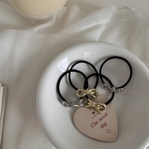 Detailed shot of metal bow hair ties in gold and silver on a white heart ceramic tray