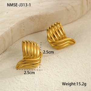 Detailed view of 2.5cm gold textured wave stud earrings on a stone surface