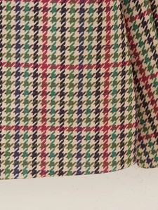 Detailed macro view of multi-colored houndstooth wool blend fabric for blazer