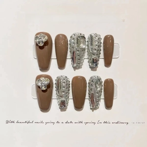 Detail of mocha brown and silver glitter press-on nails with 3D floral rhinestones