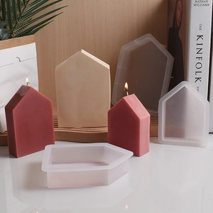 Detailed view of house shaped silicone molds with red and beige wax candle finished crafts