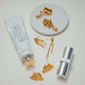 Golden fluid lava earrings set with white pearls in high polish stainless steel