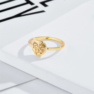 Detailed view of an 14k gold-plated ring with a delicate floral engraving on a round face