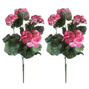 Close-up of two artificial pink geranium flower bouquets with green leaves on white background