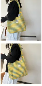 Detail of soft plush tote bag with yellow and blue stripes and a square fabric label