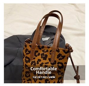 Detail of leopard print crossbody phone bag showing faux suede texture and leather handles