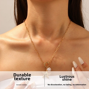 Detail shot of a gold-plated ocean star necklace with shell charm and pearl on a model