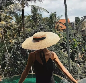 Macro detail of natural straw weaving texture and elegant black ribbon on wide-brim sun hat