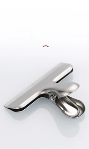 Macro shot of polished stainless steel food clip with wide mouth and brushed metal finish
