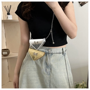 Détail du mini sac triangle bandoulière avec finition métallique et papillon en strass
