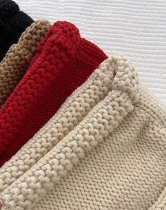 Détail de bonnets en maille monstre à côtes en noir, marron, rouge et beige pour hiver