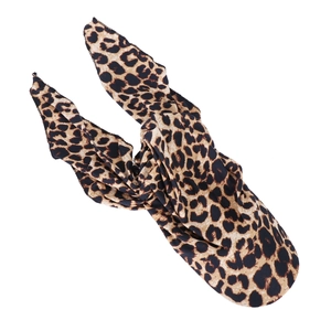 Detail view of leopard print headwrap fabric texture with long ribbon ties on white background
