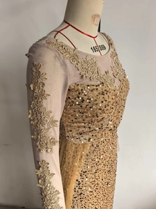 Détails de broderie en dentelle dorée et de paillettes sur une robe de soirée chic