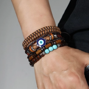 Close-up of men's layered beaded bracelet with wooden beads and blue evil eye charm
