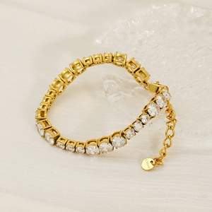 Detail of gold tennis bracelet with cubic zirconia and S.Steel hallmark on the pendant