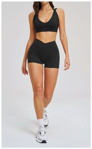 Dettaglio reggiseno sportivo nero e pantaloncini yoga a vita alta con tasche laterali