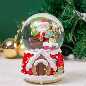 Macro view of Christmas snow globe featuring Santa Claus and red cottage embossed base
