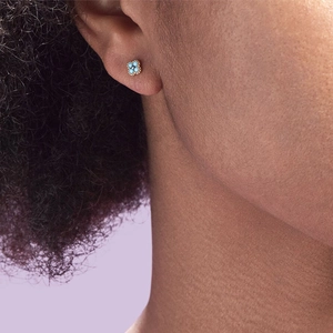 Close-up of vintage s925 silver turquoise clover earring worn on earlobe with gold beads