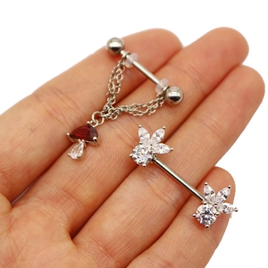 Detail of stainless steel body piercing rings with mushroom pendant and zircon flower studs