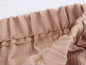 Gros plan sur la taille élastique en tissu texturé rose nude avec coutures détaillées